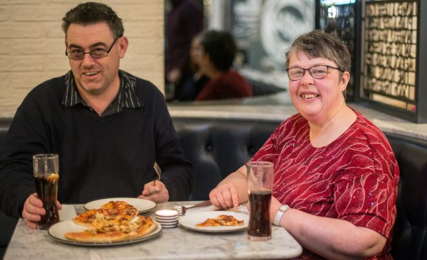 dates-n-mates members Liz and Chris eating at a restaurant and smiling